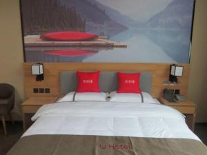 1 dormitorio con 1 cama grande con almohadas rojas en Thank Inn Chain Hotel Shangrao Houjiagang Poyang, 
