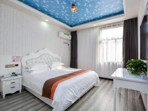 Łóżko lub łóżka w pokoju w obiekcie JUN Hotels Jiangsu Nanjing Railway Station Sun Yat-sen Mausoleum Scenic Area