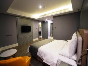 a bedroom with a bed and a table and a tv at Lano Hotel Guizhou Zunyi Renhuai Power Supply Bureau Office Building in Zunyi