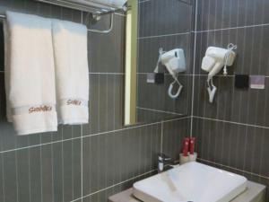 y baño con lavabo, espejo y toallas. en Thank Inn Chain Hotel Shangrao Houjiagang Poyang, 