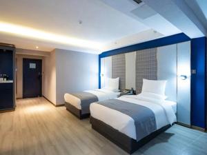 una camera d'albergo con due letti e un bagno di Lano Hotel Guiyang High Speed Rail North Station Dream City a Guiyang