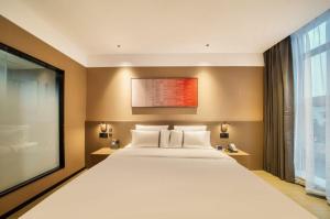 ein Schlafzimmer mit einem großen weißen Bett und einem Fenster in der Unterkunft Thank Inn Chain Hotel Jiangsu Changshu Meili Town Meili in Xuxiang