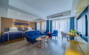 Habitación de hotel con cama y sala de estar. en LanOu Hotel Chongqing Shapingba University City, en Tuzhu
