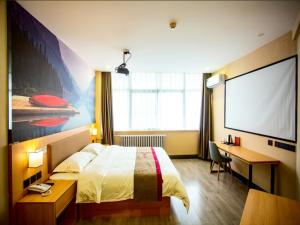 a hotel room with a bed and a projection screen at Thank Inn Plus Hotel Shandong Liaocheng Railway Station in Liaocheng