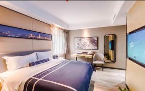 a hotel room with a large bed and a television at LanOu Hotel Zhengzhou High-Tech Zone Headquarter Enterprise Base in Zhengzhou