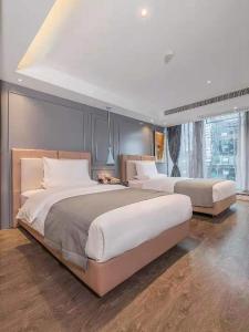 Lano Hotel Guizhou Zunyi Xinpu New District Linda Sunshine City في زونيي: غرفة نوم كبيرة بسريرين ونافذة كبيرة