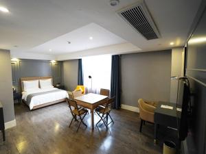 a hotel room with a bed and a table and chairs at Lano Hotel Guizhou Zunyi Renhuai Power Supply Bureau Office Building in Zunyi