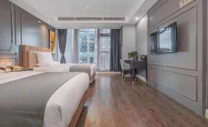 Habitación de hotel con 2 camas, escritorio y TV. en Lano Hotel Guizhou Zunyi Xinpu New District Linda Sunshine City, en Zunyi