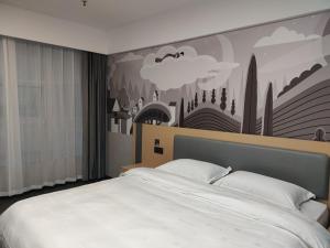 a bedroom with a large bed with a painting on the wall at Thank Inn Plus Hotel Shandong Jining Liangshan County Xuji Zhengyang in Jining