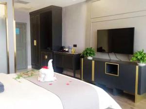 een hotelkamer met een bed en een flatscreen-tv bij Lano Hotel Xilinhot Taipusi Banner South Jianshe Road 