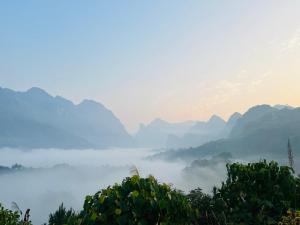 a view of a misty valley with mountains in the background at Du Già Coffee View Homestay in Làng Cac
