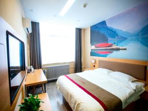 a bedroom with a bed and a large painting on the wall at Thank Inn Plus Hotel Shandong Liaocheng Railway Station in Liaocheng