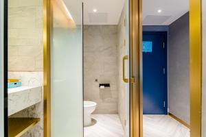 baño con aseo y puerta azul en Lano Hotel Guiyang Midea Guobinfu University Town, en Guiyang