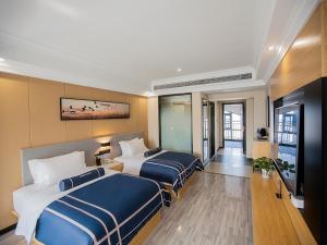 a hotel room with two beds and a television at LanOu Hotel Yellowstone Harbor Area Moore Cityland in Huangshi