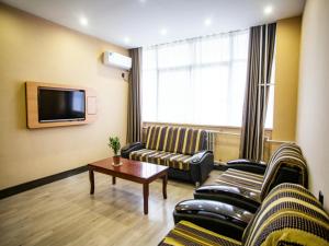 a living room with two couches and a tv at Thank Inn Plus Hotel Shandong Liaocheng Railway Station in Liaocheng