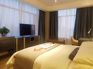 pokój hotelowy z dużym łóżkiem i telewizorem z płaskim ekranem w obiekcie Lano Hotel Xilinhot Taipusi Banner South Jianshe Road 