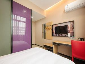 una camera con letto, scrivania e TV di Thank Inn Chain Hotel jiangxi nanchang west lake district August 1st plaza a Nanchang