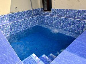 uma piscina de azulejos azuis numa casa em Beach home em Cheyūr