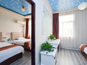 a hotel room with two beds and a mirror at JUN Hotels Jiangsu Nanjing Railway Station Sun Yat-sen Mausoleum Scenic Area in Nanjing