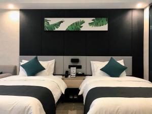 1 dormitorio con 2 camas y almohadas verdes y blancas en Thank Inn Chain Hotel Chongqing Wuxi County Shuangzitian Street, en Wuxi
