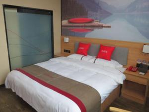 ein Schlafzimmer mit einem großen Bett mit roten Kissen in der Unterkunft Thank Inn Chain Hotel Shangrao Houjiagang Poyang 