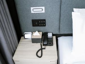un teléfono en un escritorio junto a una cama en Thank Inn Chain Hotel Hebei hengshui wuqiang zhenxing road, en Hengshui