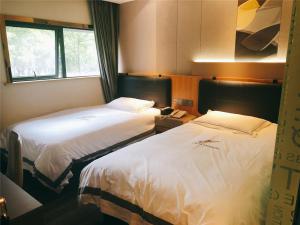 Katil atau katil-katil dalam bilik di JUNYI Hotel Nanjing Olympic Sports Center