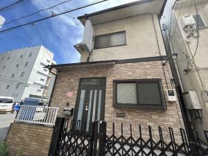 a brick house with a black fence in front of it at Kawasaki Sakula in Kawasaki