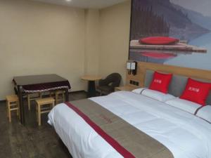 ein Hotelzimmer mit einem Bett, einem Tisch und einem Schreibtisch in der Unterkunft Thank Inn Chain Hotel Shangrao Houjiagang Poyang 