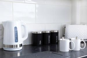 a counter top with a coffee maker and coffee cups at Bootle(Liverpool) Modern 2Bed Ft in Bootle