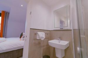 Mayfield Suites في إدنبرة: حمام مع حوض وسرير