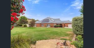 a brick house with solar panels on the roof at Top of town in Mount Martha