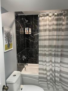 a bathroom with a toilet and a shower curtain at Cozy basement in Brampton in Brampton