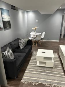 a living room with a black couch and a table at Cozy basement in Brampton in Brampton