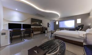 um quarto de hotel com uma cama grande e uma televisão de ecrã plano em From H sum Hotel Daejeon em Daejeon