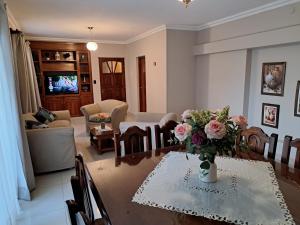 a living room with a table with a vase of flowers at Marcos Paz temporario in San Miguel de Tucumán