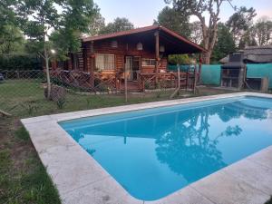 a pool in front of a log cabin at EZEIZA cedro azul 10 minutes the air port in Ezeiza