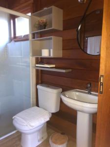 a bathroom with a toilet and a sink at Cabanas do Empório Aparados da Serra in Bom Jardim da Serra