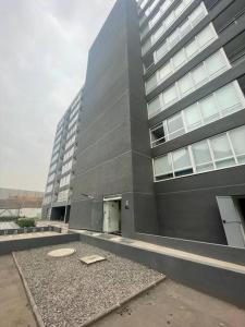 un gran edificio con una puerta delante en Departamento nuevo en Santiago