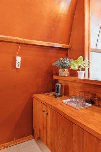 Takengon的住宿－The Lavana Jejunten Bango Takengon，厨房设有橙色墙壁和木台面