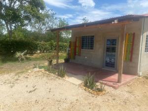 a small house with colorful doors in a yard at Cabañas Paulamar - Apto 4 - Tolú in Santiago +3 photos