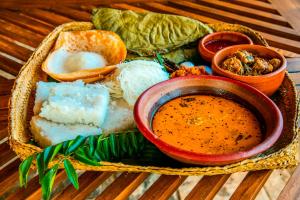a basket of food with a bowl of soup and bread at Heavens Acres Lodge in Matale