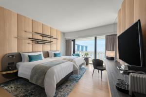 a hotel room with a large bed and a flat screen tv at PARKROYAL COLLECTION Marina Bay, Singapore in Singapore