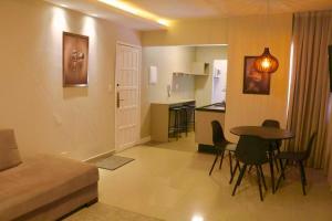 uma sala de estar com uma mesa e uma cozinha em Lindo apto 2 quartos quadra mar em Balneário Camboriú