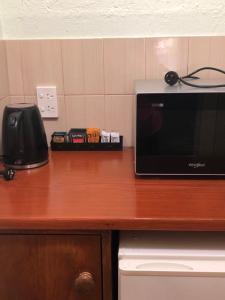 a microwave sitting on top of a wooden counter at Olde Horsham Motor Inn in Horsham