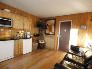a kitchen with wooden walls and wooden floors and a couch at Appartement Avoriaz, 2 pièces, 4 personnes - FR-1-314-269 in Morzine