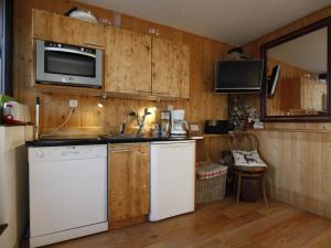 - une cuisine avec des appareils blancs et des murs en bois dans l'établissement Appartement Avoriaz, 2 pièces, 4 personnes - FR-1-314-269, à Morzine