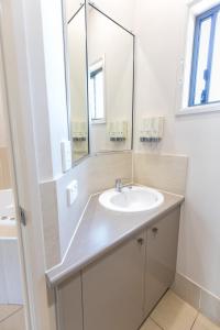 ein Bad mit einem Waschbecken und einem Spiegel in der Unterkunft Highfields Motel Toowoomba in Highfields