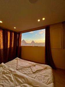 a bedroom with a bed and a large window at Pyramids Pride Inn in Cairo