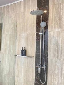 a shower with a shower head in a bathroom at Villa Akmali Umalas 2BR with Private Pool & Jacuzzi in Canggu